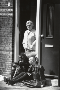 350112 Afbeelding van twee punkers en een oudere dame bij de deuropening van een huis te Utrecht.